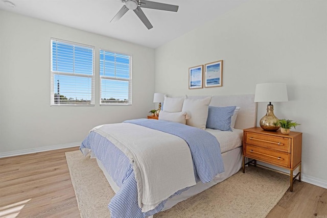 bedroom with light wood-style floors, baseboards, and a ceiling fan