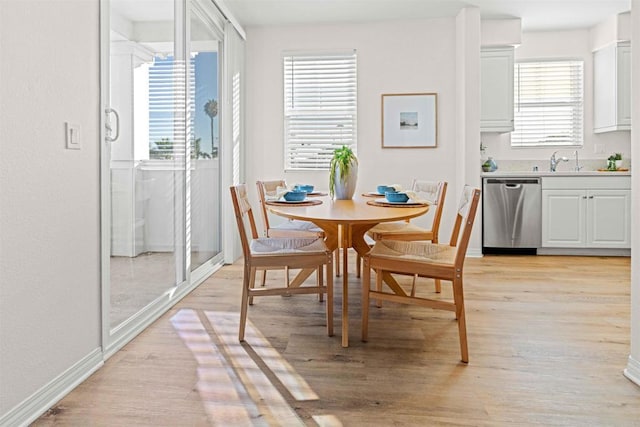 dining space with baseboards and light wood finished floors