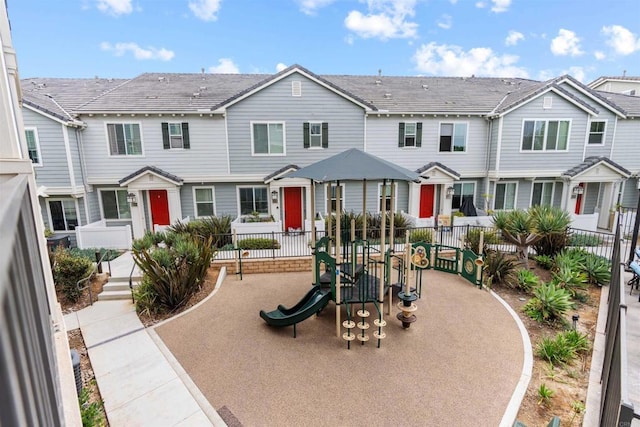 view of front of house featuring a residential view, a playground, and fence