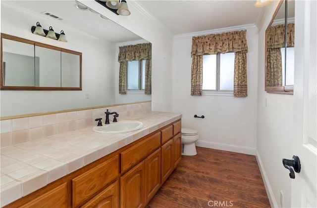 bathroom featuring visible vents, ornamental molding, wood finished floors, and toilet