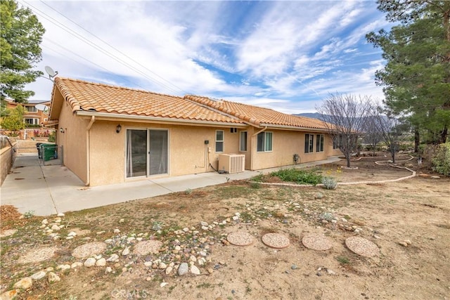 back of house with a tile roof, a patio, stucco siding, central AC, and fence