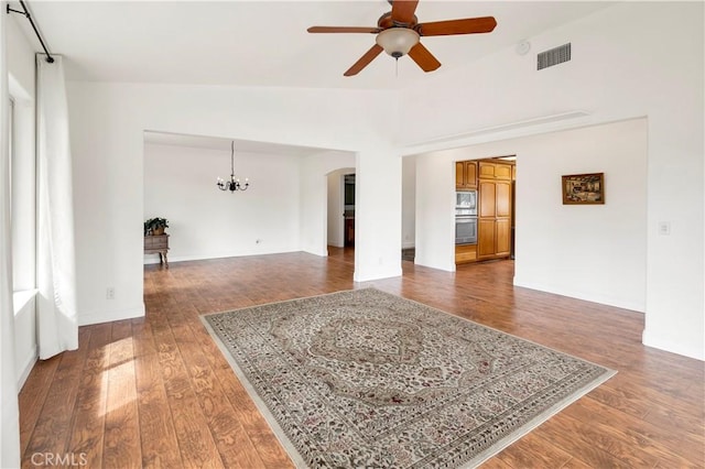 unfurnished room with lofted ceiling, wood-type flooring, visible vents, and ceiling fan with notable chandelier