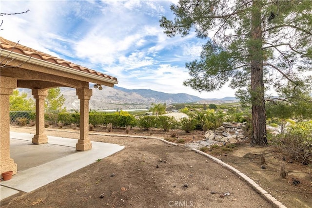 view of yard with a mountain view and a patio