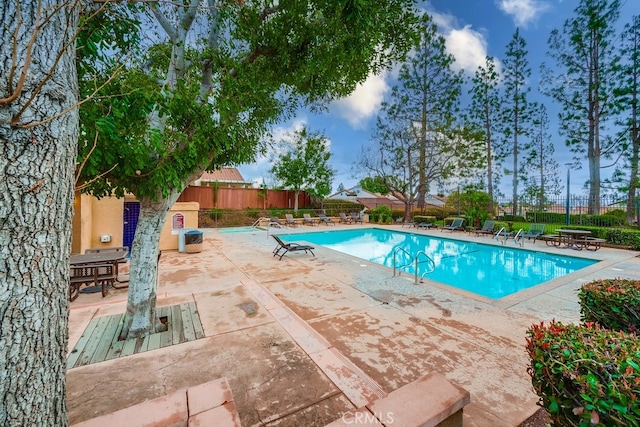 pool with fence and a patio