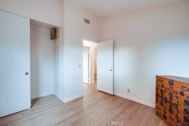 unfurnished bedroom featuring a closet, visible vents, light wood-style flooring, and baseboards