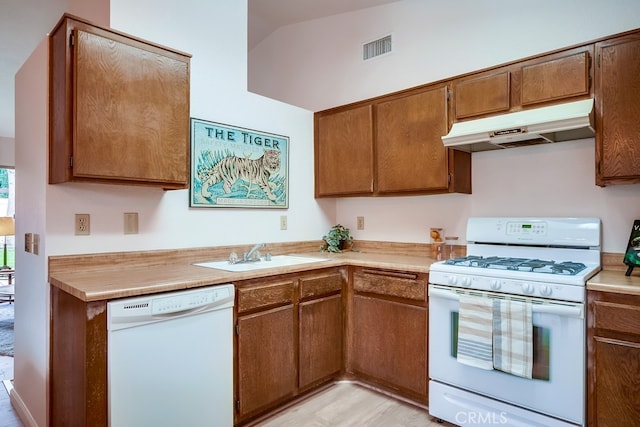 kitchen featuring under cabinet range hood, white appliances, a sink, visible vents, and light countertops