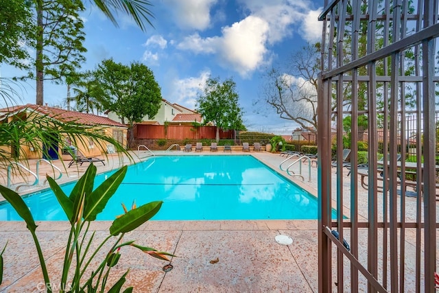 community pool featuring a patio area and a fenced backyard