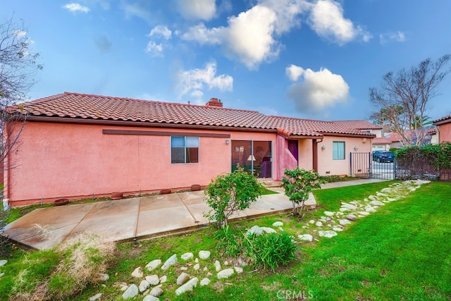 back of house featuring fence, a yard, stucco siding, a chimney, and a patio area