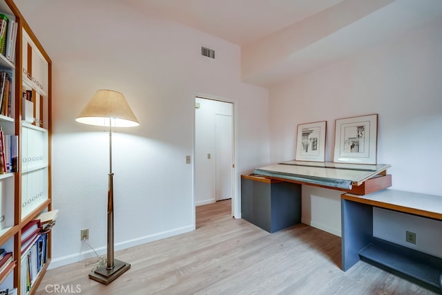 home office with baseboards, built in desk, visible vents, and light wood-style floors