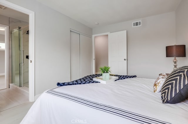 bedroom featuring a closet, visible vents, and ensuite bathroom