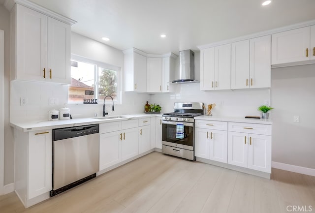 kitchen featuring decorative backsplash, wall chimney exhaust hood, light wood-style flooring, stainless steel appliances, and a sink