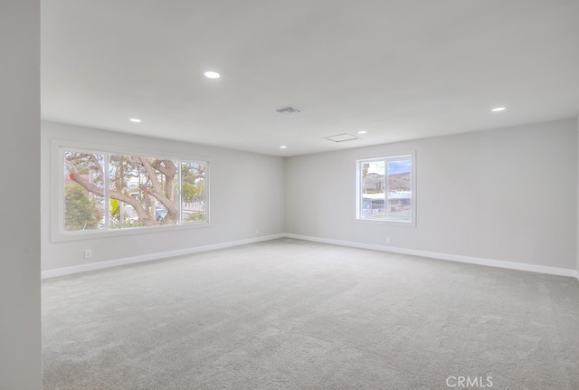 spare room featuring recessed lighting, carpet, visible vents, and baseboards