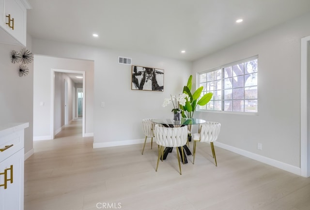 dining space with light wood-type flooring, recessed lighting, visible vents, and baseboards