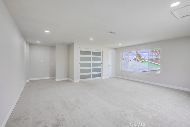 spare room featuring baseboards, light carpet, visible vents, and recessed lighting