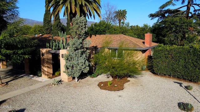 view of front of property with a chimney and roof with shingles