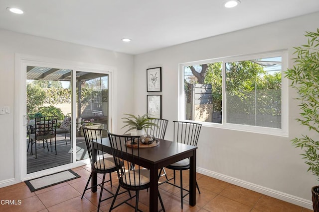 tiled dining space featuring baseboards and recessed lighting