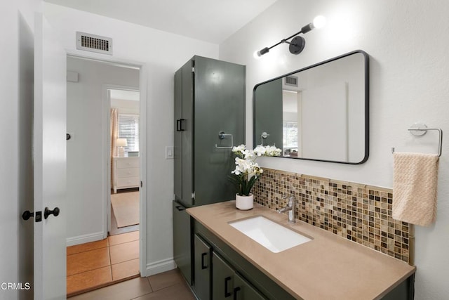 bathroom featuring vanity, visible vents, backsplash, and tile patterned floors