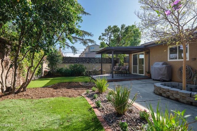 view of yard featuring a patio, an outdoor fire pit, and fence