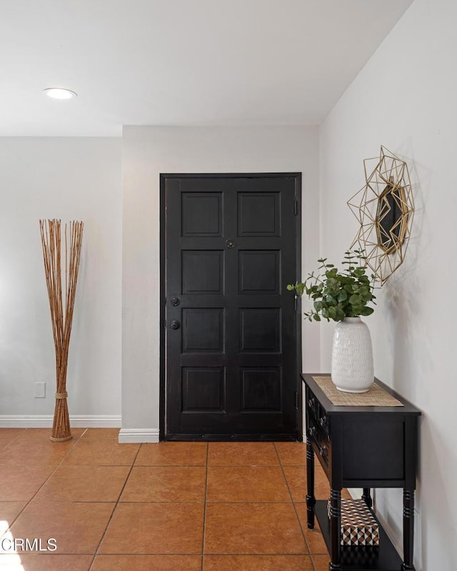 foyer featuring baseboards and light tile patterned floors