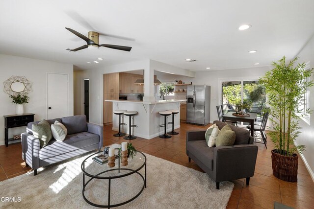 living room featuring baseboards, ceiling fan, light tile patterned flooring, and recessed lighting