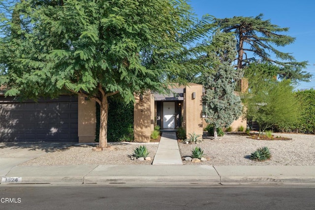 view of front of home featuring a garage, concrete driveway, and stucco siding