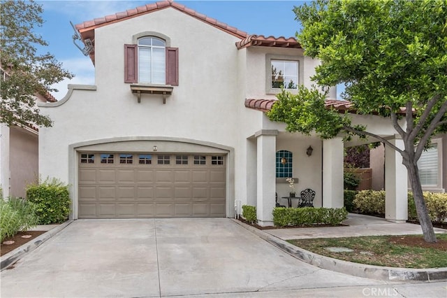 mediterranean / spanish-style home featuring stucco siding, concrete driveway, and a tile roof