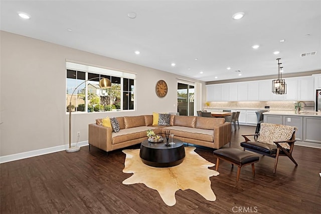 living room with baseboards, visible vents, dark wood finished floors, and recessed lighting