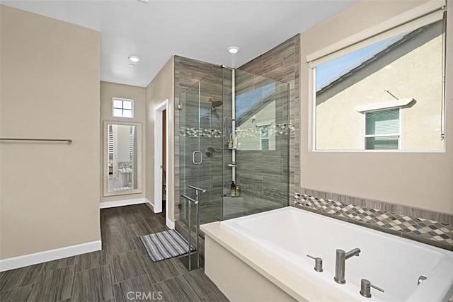 full bath with a shower stall, a bath, and baseboards