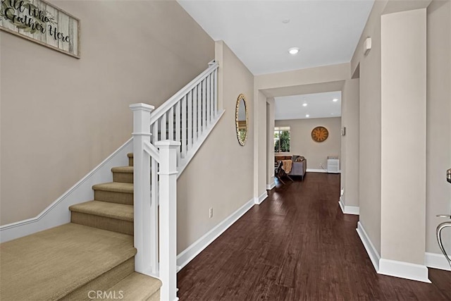 entryway with stairway, baseboards, wood finished floors, and recessed lighting