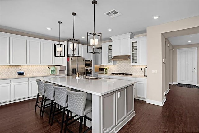 kitchen with dark wood finished floors, light countertops, visible vents, appliances with stainless steel finishes, and a sink