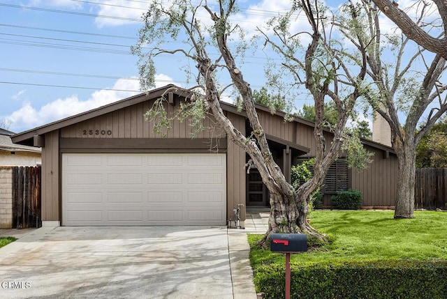 mid-century inspired home with a garage, driveway, fence, and a front yard