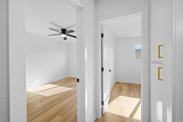 hallway featuring wood finished floors and baseboards