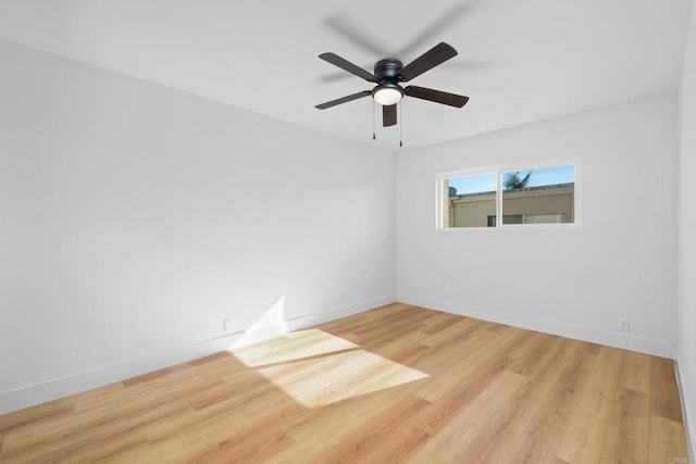 spare room featuring ceiling fan, wood finished floors, and baseboards