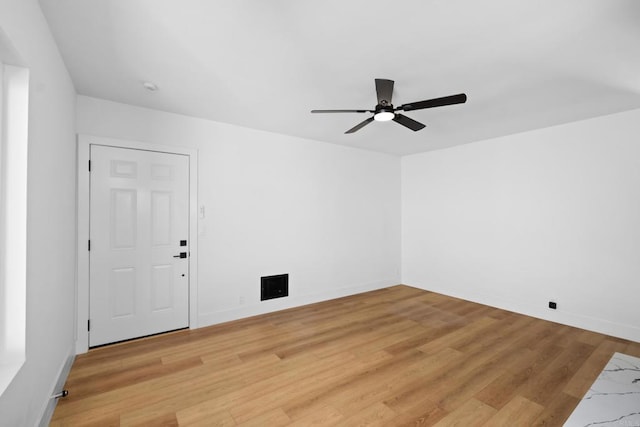 unfurnished room featuring light wood-type flooring, a ceiling fan, and baseboards