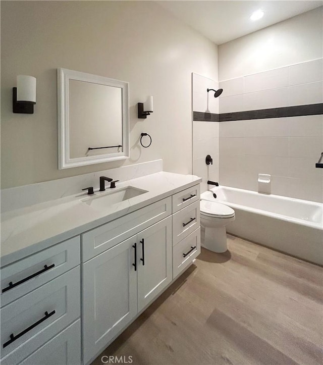 full bathroom with vanity,  shower combination, wood finished floors, and toilet