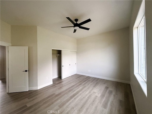 unfurnished bedroom featuring a closet, baseboards, and wood finished floors