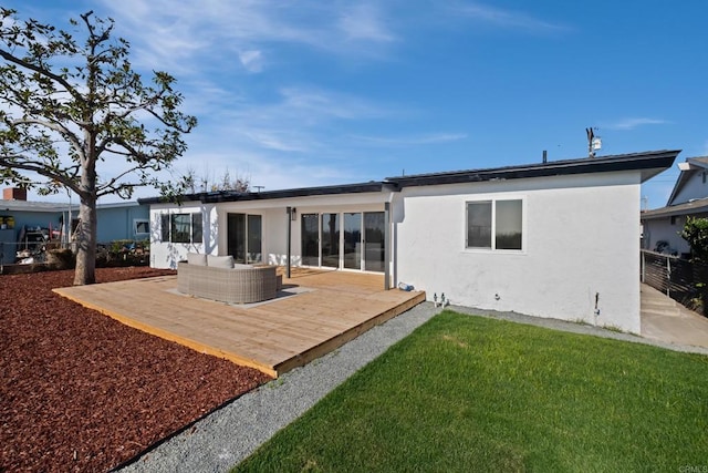 back of property featuring a wooden deck, fence, a yard, an outdoor living space, and stucco siding