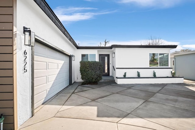 view of front of home with driveway, a garage, and stucco siding