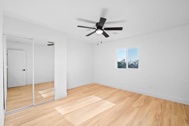 unfurnished bedroom featuring a closet, baseboards, and wood finished floors