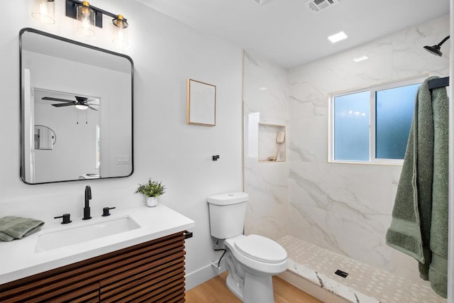 full bath with a marble finish shower, visible vents, toilet, wood finished floors, and vanity