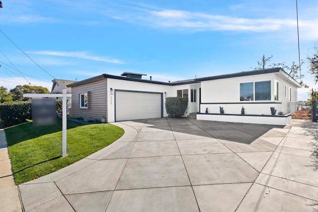 view of front of property with a garage, a front yard, driveway, and stucco siding