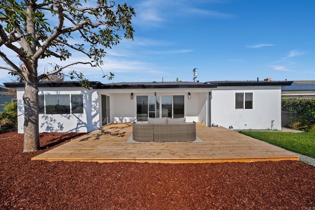 back of property with a wooden deck, outdoor lounge area, and stucco siding