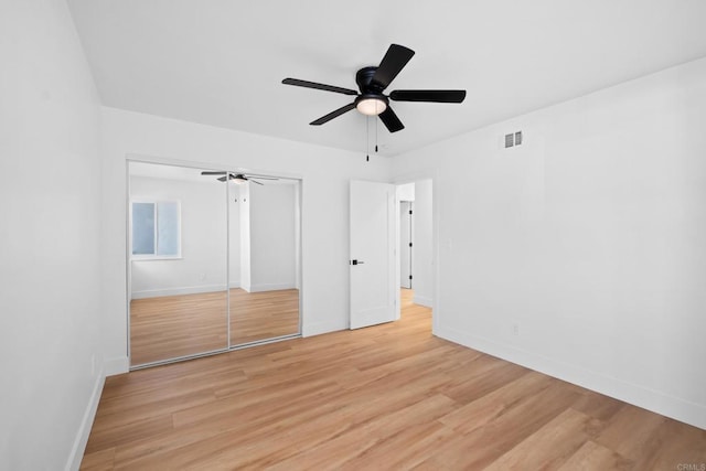 unfurnished bedroom featuring light wood-style floors, a closet, visible vents, and baseboards