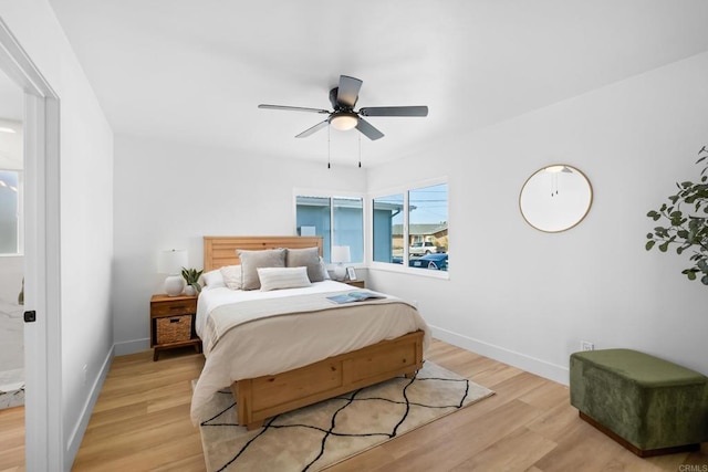 bedroom featuring ceiling fan, light wood-style flooring, and baseboards