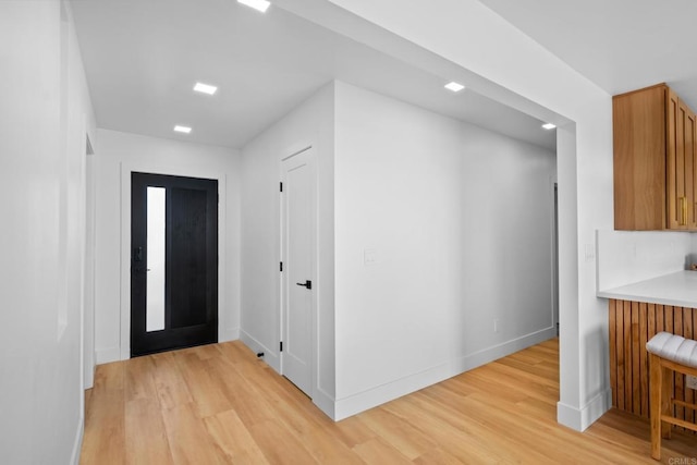 foyer with light wood-style floors and baseboards