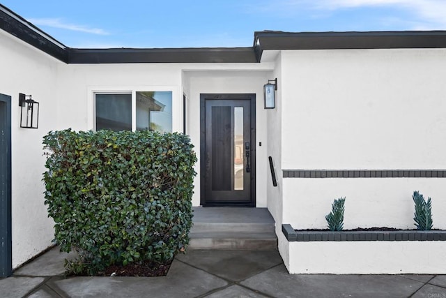 view of exterior entry featuring stucco siding