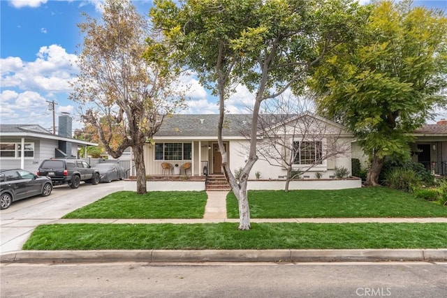 ranch-style house featuring a front yard and concrete driveway