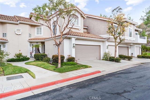 mediterranean / spanish house with concrete driveway, a chimney, a tile roof, and stucco siding