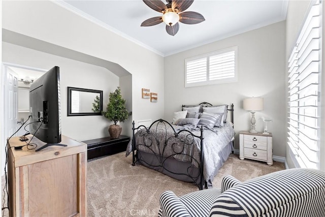 bedroom featuring light carpet, ornamental molding, and a ceiling fan