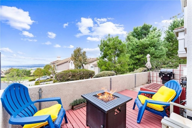 deck with an outdoor fire pit and area for grilling